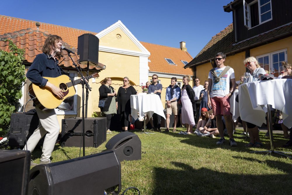 Carls Emil Pedersen spiller guitar og synger ved reception for Refshaleøen på Folkemødet 2019